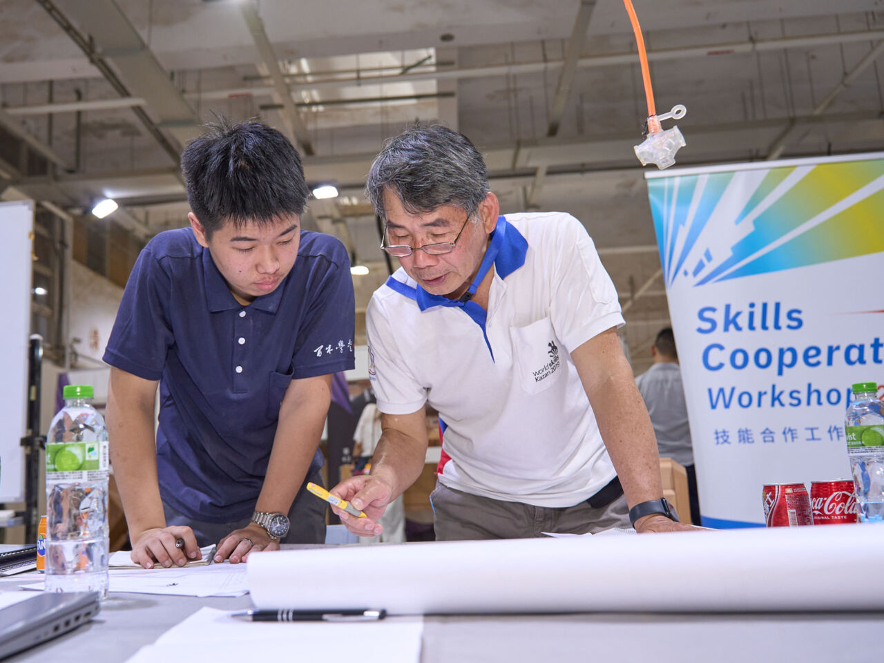 Participants stand over a desk at a Skills Cooperation Workshop hosted by WorldSkills Chinese Taipei in June and July 2024.